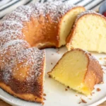 Italian Hangover Cake garnished with powdered sugar and citrus slices on a rustic table with an espresso cup